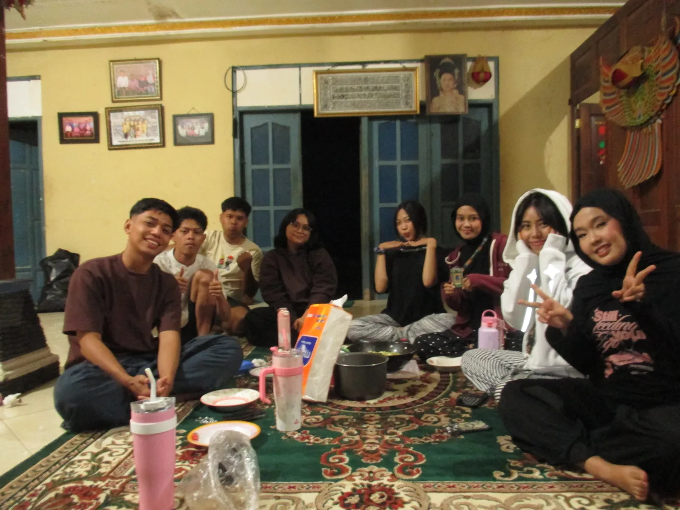 Anggota kelompok duduk santai bersama di ruang depan posko pada malam hari