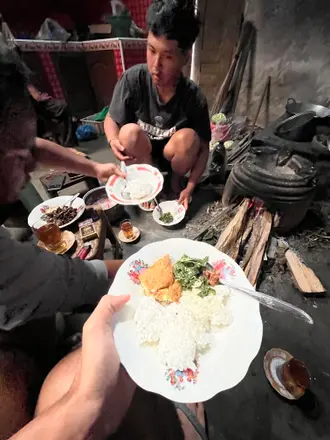 Beberapa piring nasi dan lauk dipegang berdekatan saat anggota kelompok makan bersama