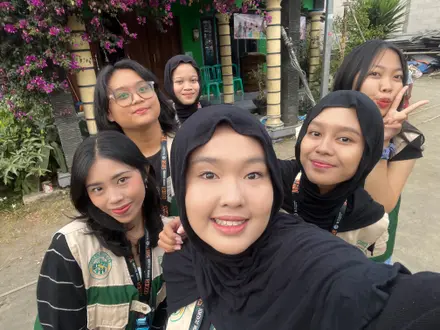 Enam anggota KKN berfoto bersama di jalan dusun mengenakan rompi kelompok