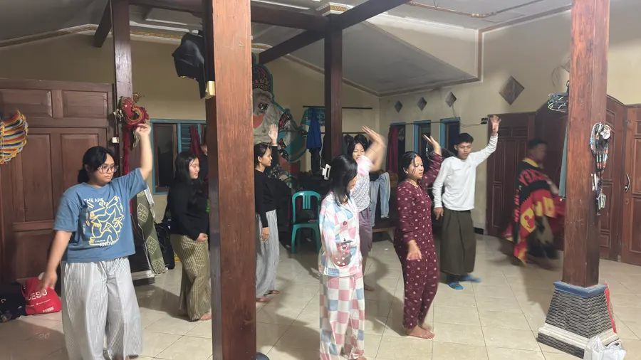 Mahasiswa dan warga berlatih gerakan tari bersama di ruang depan rumah