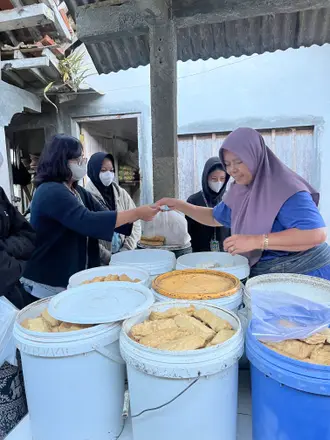 Mahasiswa berbincang dengan penjual makanan di lapak pasar tradisional