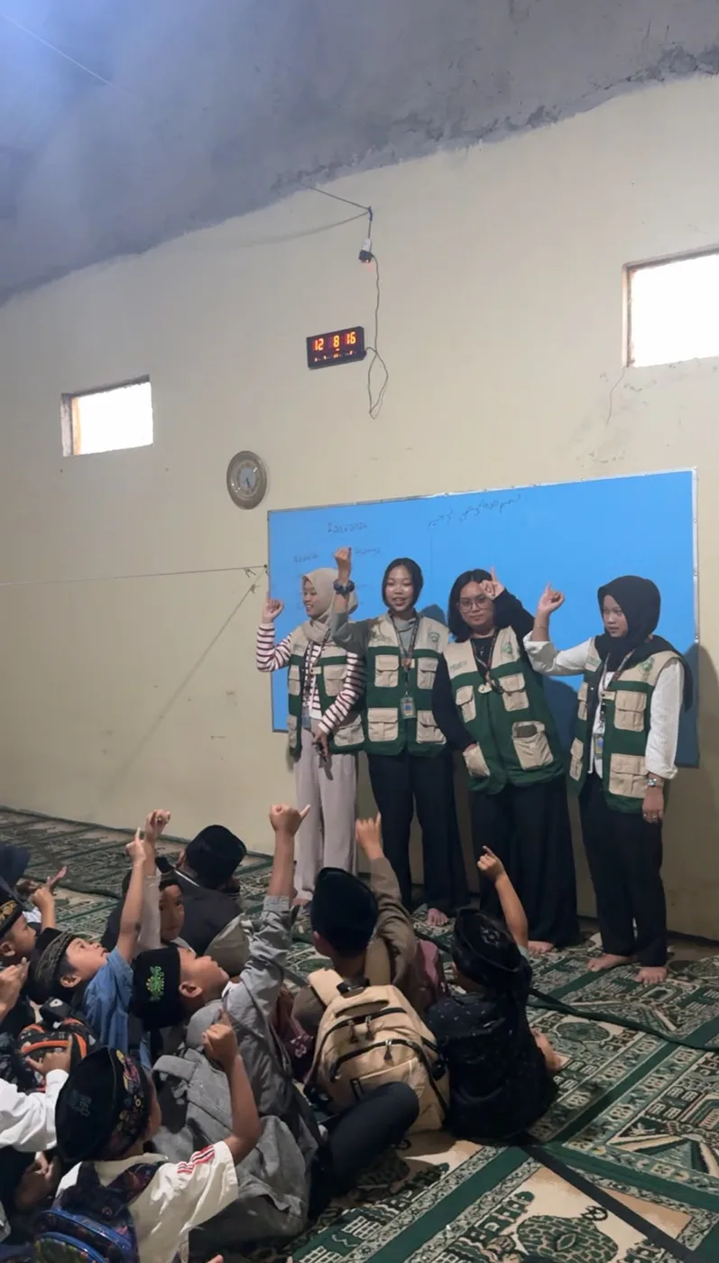 Empat mahasiswa berdiri di depan ruangan saat menyampaikan materi kepada anak-anak
