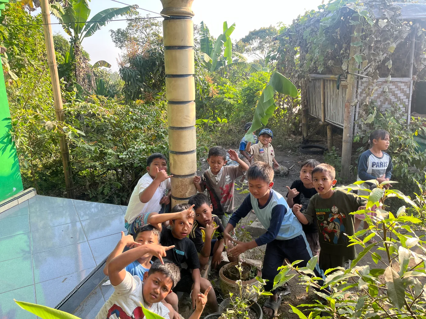 Mahasiswa dan anak-anak berfoto ramai-ramai di depan teras rumah
